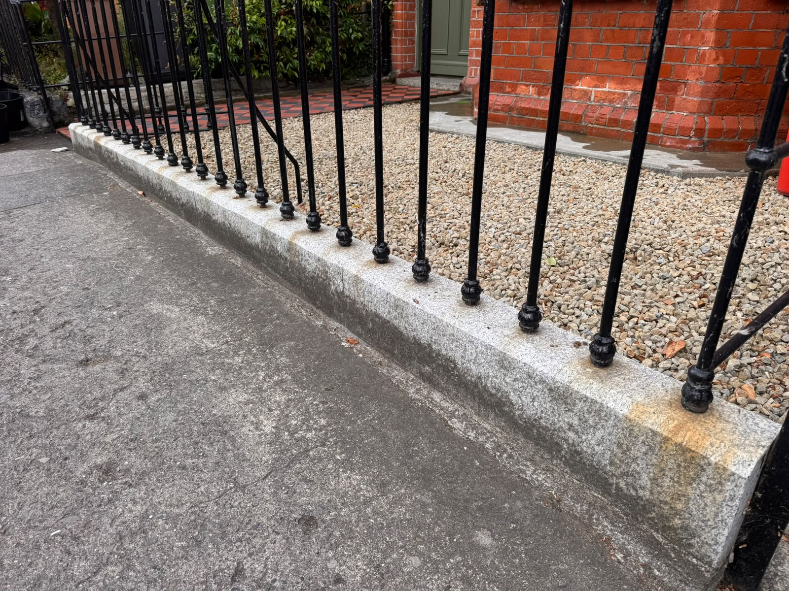 Granite kerb and front boundary before cleaning — orange staining and dirt