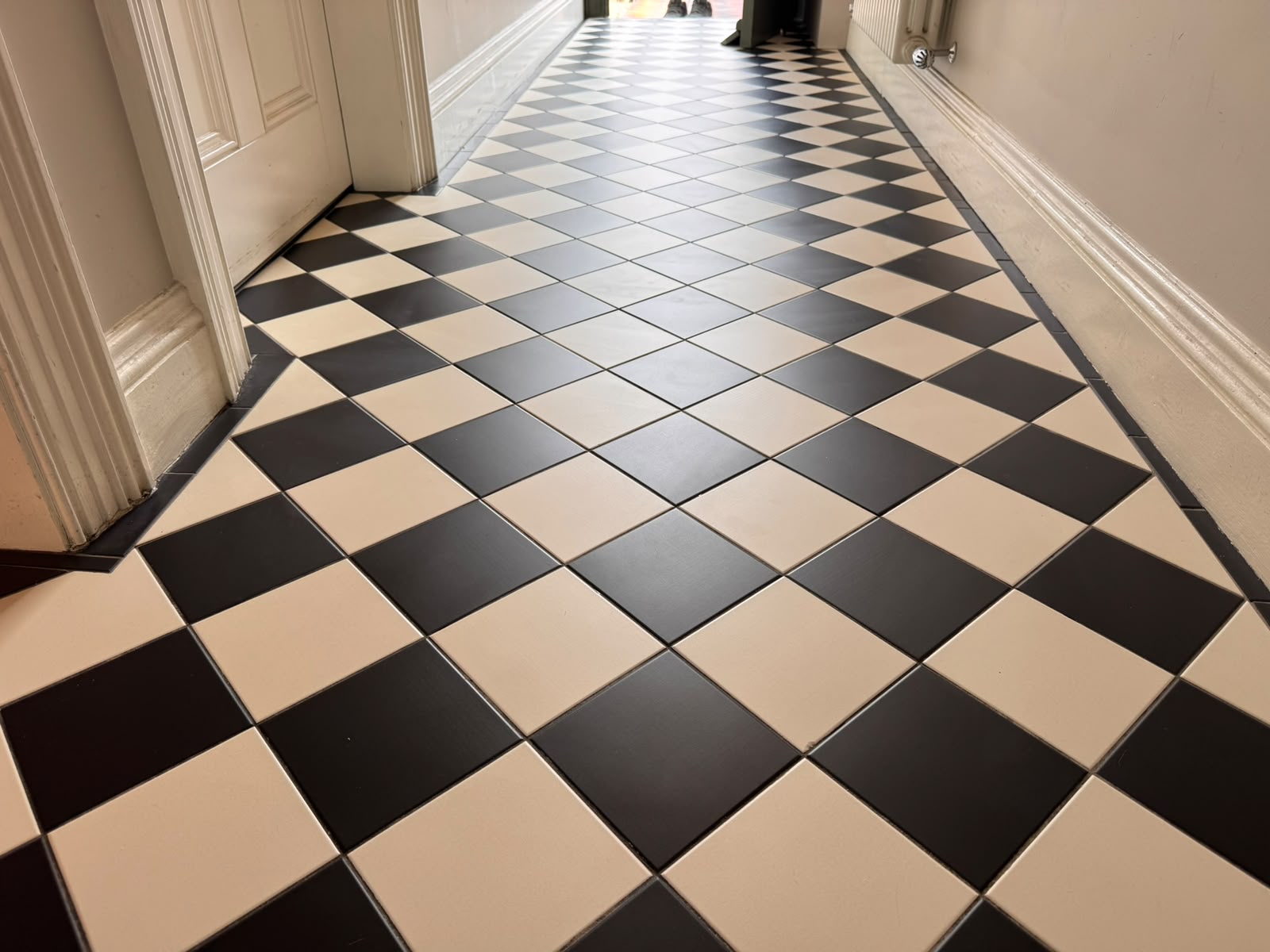 Black and cream chequerboard hallway tiles after cleaning — bright, crisp and evenly finished